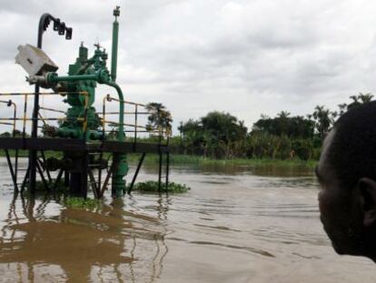 Un hombre observa un pozo de extracci&oacute;n de crudo en el rio Niger (Nigeria).