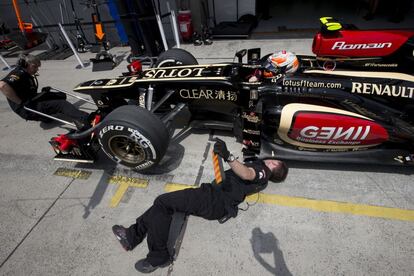 Un mecanico de Lotus revisa el coche de Romain Grosjean.