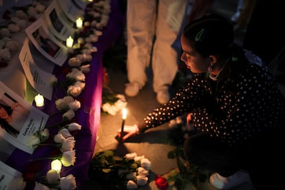 Una mujer coloca velas, durante una protesta para conmemorar el Día Internacional de la Eliminación de la Violencia contra la Mujer, en Bogotá (Colombia). 