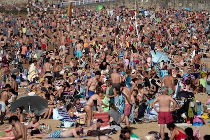 Bañistas y paseantes en la playa de San Lorenzo (Gijón).