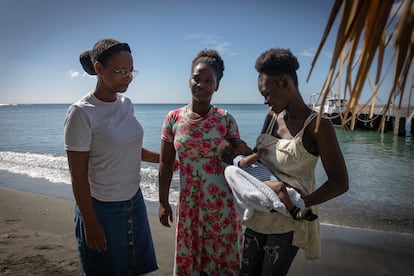 Teresa Mejía, Pahola Mola, y Dainny Mateo Mola, quien sostiene a su hijo Dylan de 3 meses, en una playa de la comunidad Sabana Grande de Palenque.