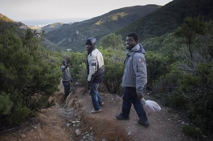 <b>En la fotografía</b>, Buback, Abderraman y Nikola descienden por una escarpada montaña, camino de las cuevas en las que duermen. Cerca de ellas, a solo diez minutos a pie, se encuentra una explanada redonda de piedras (a la que denominan "campo de fútbol") donde se concentraron los más de 300 inmigrantes que el pasado jueves intentaron traspasar la frontera ceutí. Quedaron a las doce de la noche, explican. Y a las dos de la madrugada comenzaron su marcha. Tres horas después trataron por primera vez de cruzar la valla. No tuvieron éxito. Hubo un segundo intento. Pero tampoco lo lograron. Durante el tercero, cuando se lanzaron al Mediterráneo para bordear el espigón que separa España y Marruecos, ocurrió la tragedia.