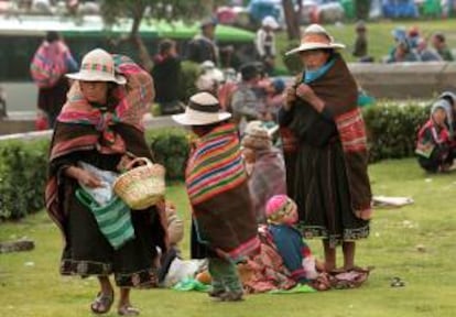 Indígenas bolivianos procedentes de las regiones rurales más pobres del altiplano descansan a las afueras de la terminal de autobuses de La Paz (Bolivia). EFE/Archivo