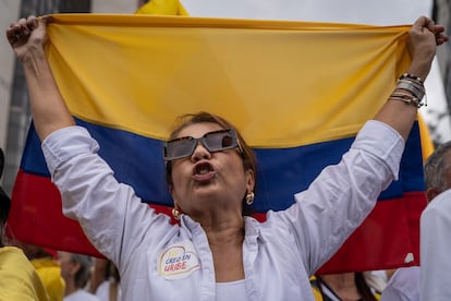 Una mujer militante del partido Centro Democrático, sostiene una bandera de Colombia durante la protesa.