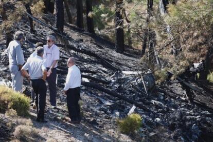 Técnicos de aviación civil revisan la zona siniestrada y los restos del helicóptero en Granada.