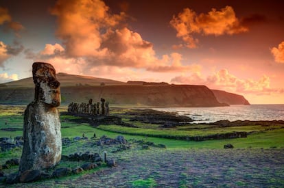 Un solitario moái y al fondo la hilera de estatuas de piedra de Ahu Tongariki, en la isla de Pascua.