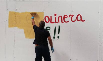 Un operario pinta un grafiti en el mural de La Gasolinera que borró el Ayuntamiento el sábado.