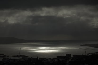 Um ponto de luz atravessa as nuvens e brilha em um navio no mar durante a fase parcial do eclipse solar em 20 de março, em Tórshavn, capital das Ilhas Feroe.