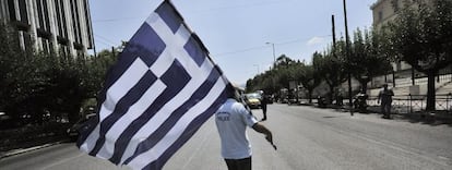 Un manifestante porta una bandera griega frente al Parlamento heleno en una imagen de archivo