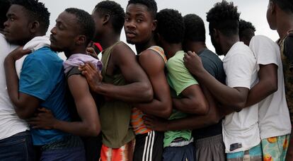 Un grupo de migrantes haitianos hacen fila para comer en un campamento operado por el Gobierno cubano después de que su barco con destino a Estados Unidos se desviara del rumbo y llegara a la costa norte de Cuba, en Sierra Morena.