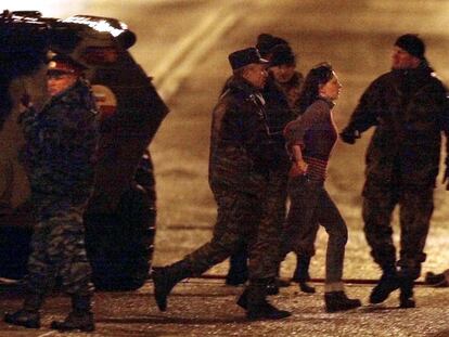TOPSHOT - Russian special forces officers evacuate early 26 October 2002an unidentified hostage from the Dubrovka theater in Moscow, where a number of Chechen rebels were holding some 700 theatre-goers hostage since 23 October. Thirty-six Chechen rebels were killed today when security forces stormed the building, Russian Deputy Interior Minister Vladimir Vasilyev said. Among the dead were all the Chechen kamikaze women who had explosives strapped to their bodies, he added.    AFP PHOTO/ Alexander NEMENOV (Photo by Alexander NEMENOV / AFP) (Photo by ALEXANDER NEMENOV/AFP via Getty Images)