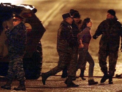 TOPSHOT - Russian special forces officers evacuate early 26 October 2002an unidentified hostage from the Dubrovka theater in Moscow, where a number of Chechen rebels were holding some 700 theatre-goers hostage since 23 October. Thirty-six Chechen rebels were killed today when security forces stormed the building, Russian Deputy Interior Minister Vladimir Vasilyev said. Among the dead were all the Chechen kamikaze women who had explosives strapped to their bodies, he added. AFP PHOTO/ Alexander NEMENOV (Photo by Alexander NEMENOV / AFP) (Photo by ALEXANDER NEMENOV/AFP via Getty Images)