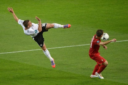 Podolski remata a portería ante la oposición de Joao Pereira.