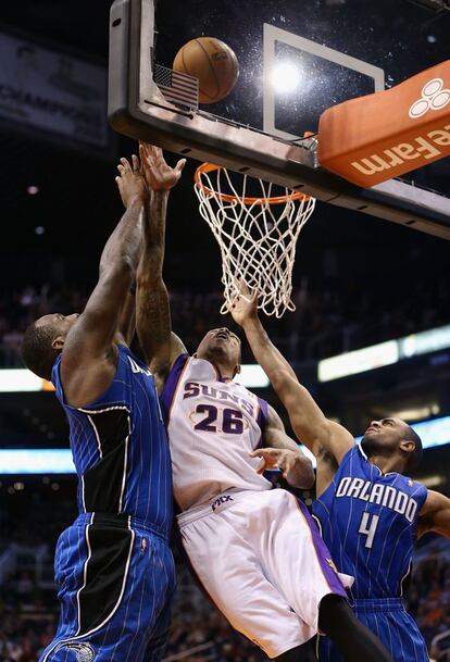 Glen Davis y Arron Affalo, de Orlando Magic, tratan de impedir una canasta de Shannon Brown, de Phoenix Suns