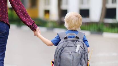 Un niño se dirige al colegio con su madre.