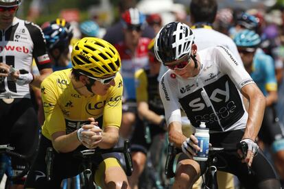 El holandés Tom Dumoulin, el británico Geraint Thomas -luciendo el maillot amarillo del líder general- y el británico Chris Froome, desde la izquierda, esperan en la parrilla de inicio, similar a la Fórmula 1, antes de la decimoséptima etapa de la carrera ciclista del Tour de Francia