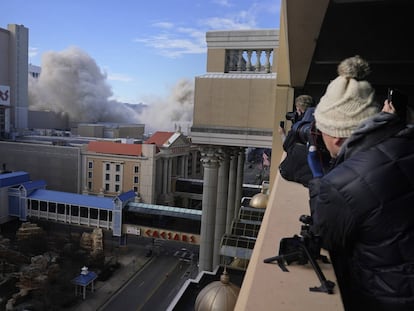 People watch as a dust cloud rises after the former Trump Plaza casino was imploded on Wednesday, Feb. 17, 2021, in Atlantic City, N.J. After falling into disrepair, the one-time jewel of former President Donald Trump's casino empire is reduced to rubble, clearing the way for a prime development opportunity on the middle of the Boardwalk, where the Plaza used to market itself as 