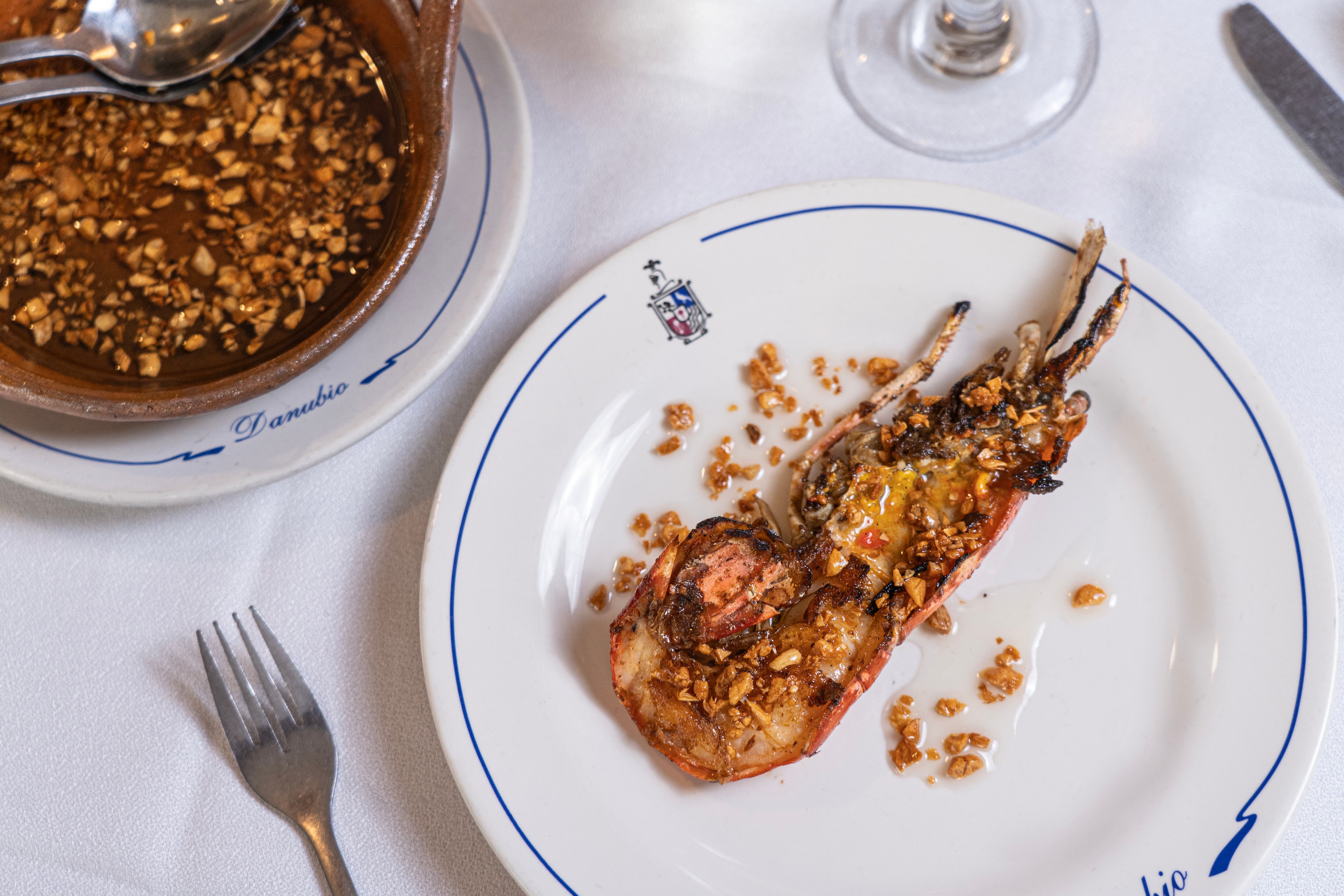 Un langostino, acompañado de una copa de vino blanco.