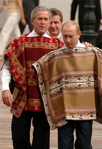 Bush y Putin se dirigen a posar para la foto de familia de la cumbre vestidos con un poncho tradicional chileno.