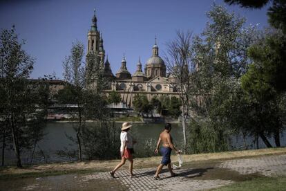 Una pareja pasea junto al río, este miércoles, en Zaragoza.