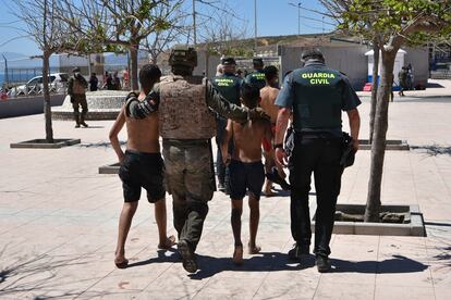 Militares y guardias civiles llevan a la frontera a dos menores que entraron a Ceuta el pasado 19 mayo.