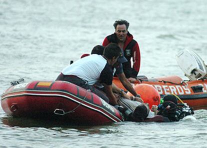 Los bomberos de Zaragoza rescatan el cadáver de uno de los fallecidos ayer en el embalse de Mequinenza.