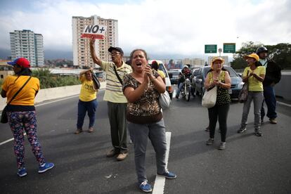 Partidarios de la oposición muestran un cartel que dice "No más dictadura" durante una protesta contra el gobierno de Nicolás Maduro, en Caracas.