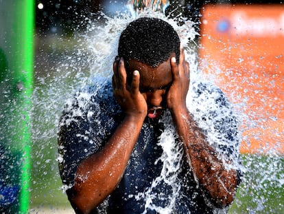 A man cools off in a water fountain in Texas on June 20, 2023.