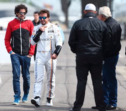 El piloto español Fernando Alonso (c) conversa sus primeras prácticas en el circuito de Indianápolis.