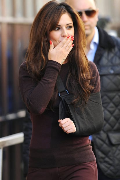 Cheryl Cole no pierde la sonrisa ni con el brazo escayolado al dedicar un cariñoso gesto a sus fans.