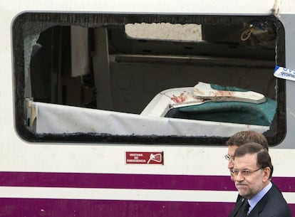 Mariano Rajoy camina junto a N&uacute;&ntilde;ez Feij&oacute;o junto a uno de los vagones siniestrados. 