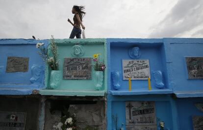 Una joven camina entre los nichos de un cementerio al norte de Manila (Filipinas).