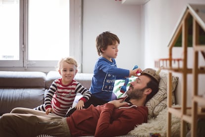 Un padre juega con sus hijos. 