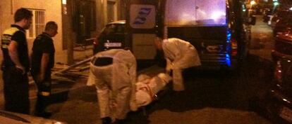 Operarios del tanatorio trasladan el cuerpo de la víctima.