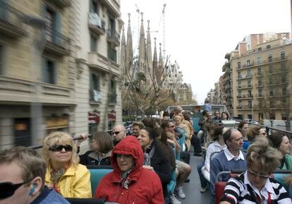 Un grupo de turistas, en autob&uacute;s cerca de la Sagrada Familia, en Barcelona