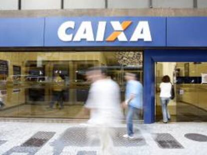 En la imagen, transeúntes caminan frente a una sucursal del estatal Caixa Económica Federal, en Río de Janeiro (Brasil). EFE/Archivo