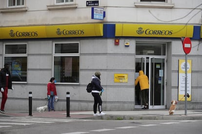 Varias personas hacen cola en una oficina de Correos en Madrid este lunes, decimosexto día de aislamiento tras el estado de alarma decretado por el Gobierno para frenar el avance del coronavirus.