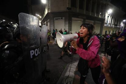 Una mujer arenga a las manifestantes ante los agentes de polica en la marcha por el 8-M en Quito (Ecuador).