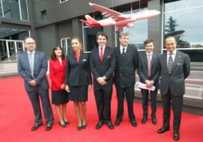 El presidente de IAG e Iberia, Antonio Vázquez (d); el consejero delegado de Iberia, Luis Gallego (i), y el director del área general Comercial y de Clientes de la compañía, Marcos Sansavini (2d), posan junto a cuatro empleados de la compañía, durante la presentación de la nueva marca de la aerolínea.