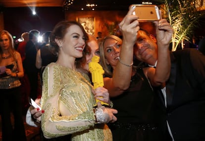 La actriz Emma Stone posa para un selfie con otros invitados a la fiesta del Gobernador tras la celebración de la gala