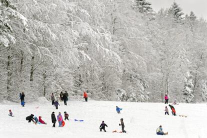 Un grup de gent es diverteix a la neu a Chalet-a-Gobet, a Lausana, Suïssa.