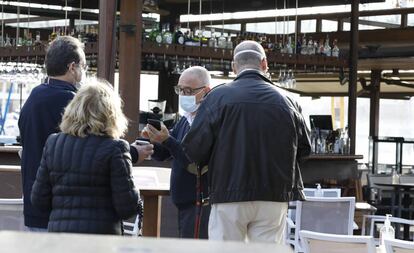 Los clientes muestran a un camarero su pasaporte Covid en un bar de Palma de Mallorca.