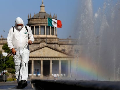 Un trabajador vestido con traje de protección rocía desinfectante durante una campaña de saneamiento de espacios públicos como medida preventiva contra la propagación del nuevo coronavirus, COVID-19, en Guadalajara, México, el 20 de marzo de 2020