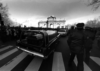 Un coche fúnebre, que traslada los restos de Enrique Tierno Galván al cementerio de la Almudena, a su paso por la Puerta de Alcalá, el 21 de enero de 1986.