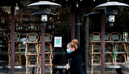 Una mujer pasa, la semana pasada, frente a la puerta de un restaurante cerrado en París.