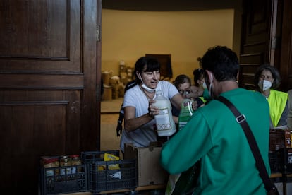 Vecinos reciben alimentos y productos en la parroquia San Ramón de Paiporta este lunes.