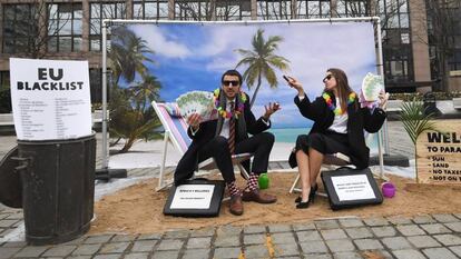Dos activistas de Oxfam realizan una protesta satírica frente a las instituciones europeas en Bruselas para llamar la atención sobre los paraísos fiscales.
