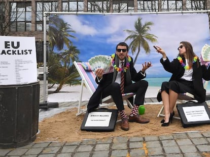 Dos activistas de Oxfam realizan una protesta sat&iacute;rica frente a las instituciones europeas en Bruselas para llamar la atenci&oacute;n sobre los para&iacute;sos fiscales.