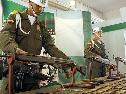 Policías colombianos muestran armas y municiones incautadas al ELN en el departamento de Antioquia.