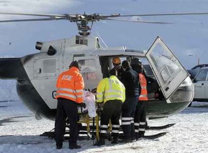 Los equipos de rescate tratan de trasladar a uno de los heridos, que falleció después, a una UVI móvil.